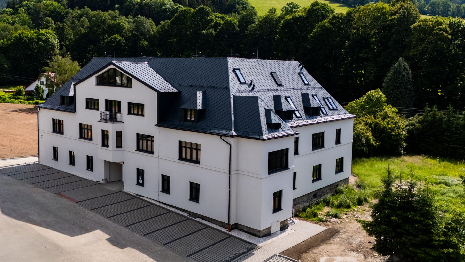 Na obrázku je dům s příjezdovou cestou, jedná se o areál Údolí Rejhotice